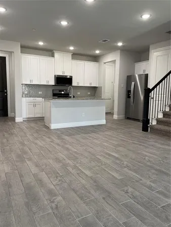 a view of kitchen with stainless steel appliances granite countertop a stove a sink and a refrigerator