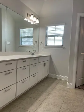 a spacious bathroom with a double vanity sink a mirror and a bathtub