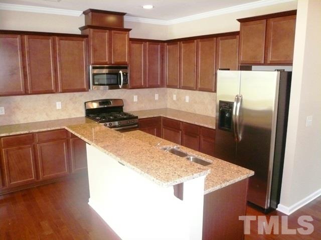 213 Irving Way, Unit 69 Durham, NC 27703 - Photo 1 of 25 a kitchen with kitchen island granite countertop a sink a stove and refrigerator