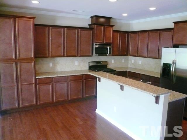213 Irving Way, Unit 69 Durham, NC 27703 - Photo 2 of 25 a kitchen with granite countertop wooden cabinets a sink and dishwasher