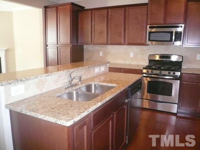 213 Irving Way, Unit 69 Durham, NC 27703 - Photo 5 of 25 a kitchen with stainless steel appliances granite countertop a sink stove and refrigerator