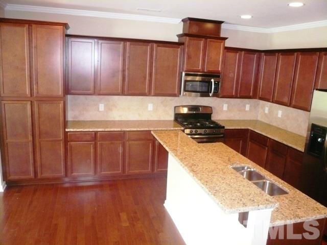 213 Irving Way, Unit 69 Durham, NC 27703 - Photo 7 of 25 a kitchen with granite countertop wooden cabinets and a granite counter top