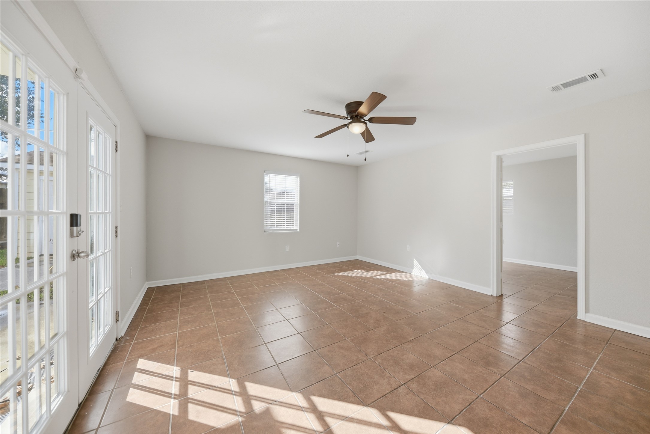 1702 Rampart Street Columbus, TX 78934 - Photo 20 of 38 Spare room with light tile patterned floors, french doors, and a ceiling fan