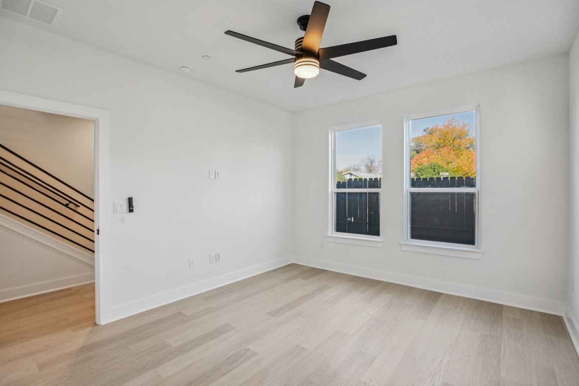 200 West 56th Street, Unit 2104 Austin, TX 78751 - Photo 11 of 36 an empty room with wooden floor fan and windows