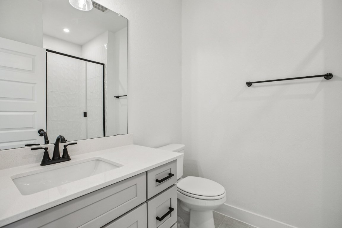 200 West 56th Street, Unit 2104 Austin, TX 78751 - Photo 14 of 36 a bathroom with a sink a toilet and a mirror