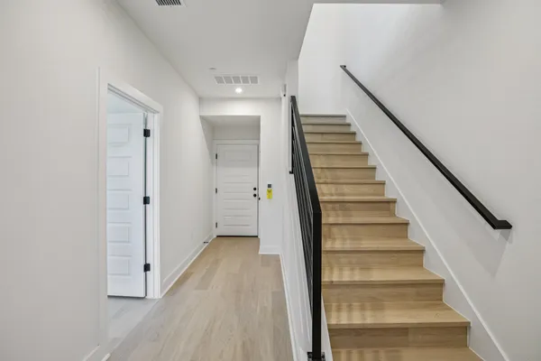 a view of a hallway with wooden floor and entryway