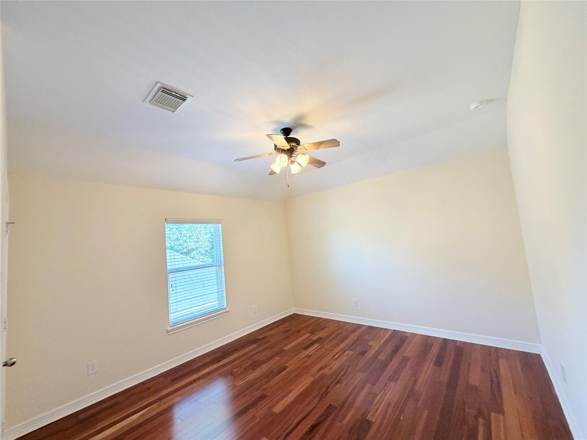 28015 Silverstream Court Fulshear, TX 77441 - Photo 23 of 33 an empty room with wooden floor fan and windows