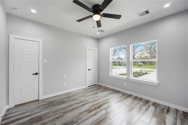 a view of an empty room with a window and a ceiling fan