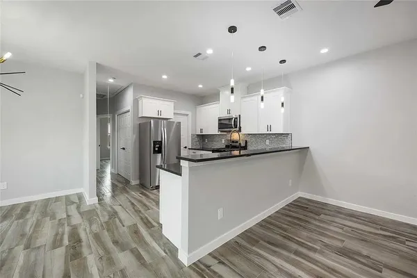 a kitchen with stainless steel appliances granite countertop a refrigerator and a sink