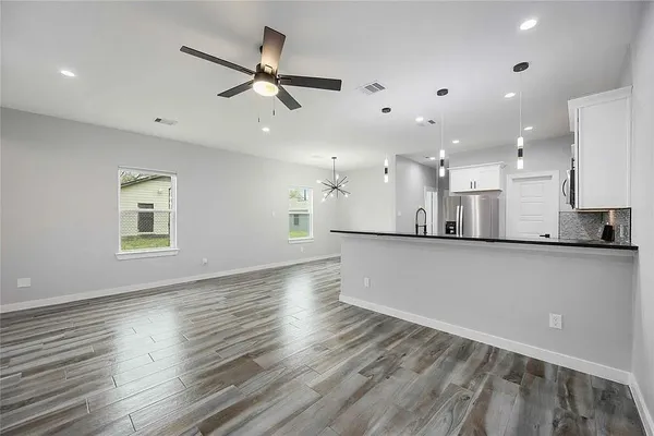 a view of a kitchen with a sink and wooden floor