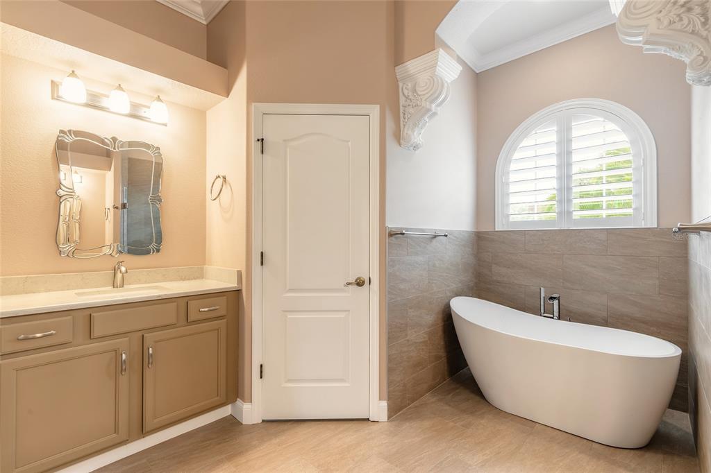 3343 West Locanda Circle New Smyrna Beach, FL 32168 - Photo 20 of 55 a bathroom with a white tub a sink and a window