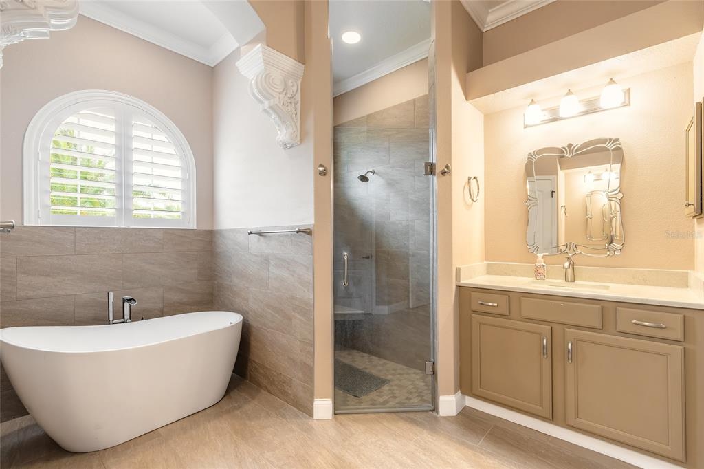 3343 West Locanda Circle New Smyrna Beach, FL 32168 - Photo 21 of 55 a bathroom with a white tub a shower and a sink