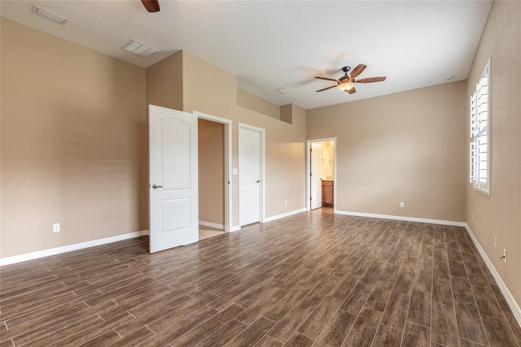 3343 West Locanda Circle New Smyrna Beach, FL 32168 - Photo 28 of 55 a view of empty room with wooden floor and fan