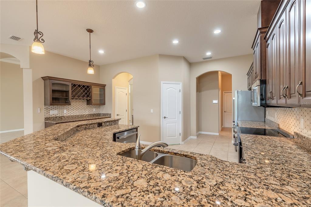 3343 West Locanda Circle New Smyrna Beach, FL 32168 - Photo 3 of 55 a large kitchen with kitchen island granite countertop a sink and a stove