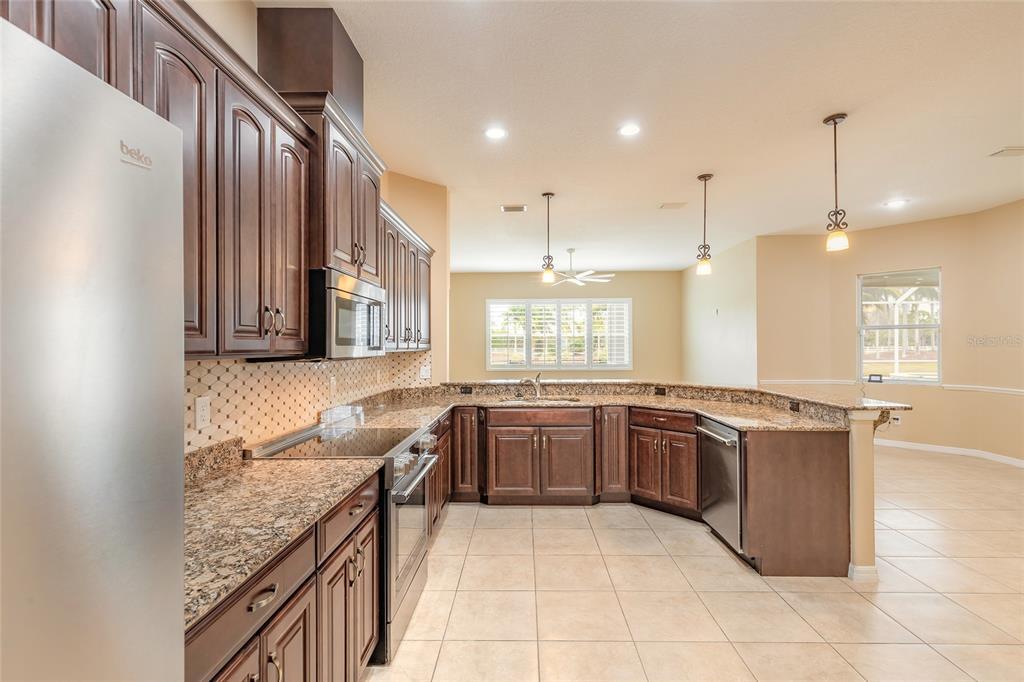3343 West Locanda Circle New Smyrna Beach, FL 32168 - Photo 5 of 55 a large kitchen with granite countertop a stove and a sink