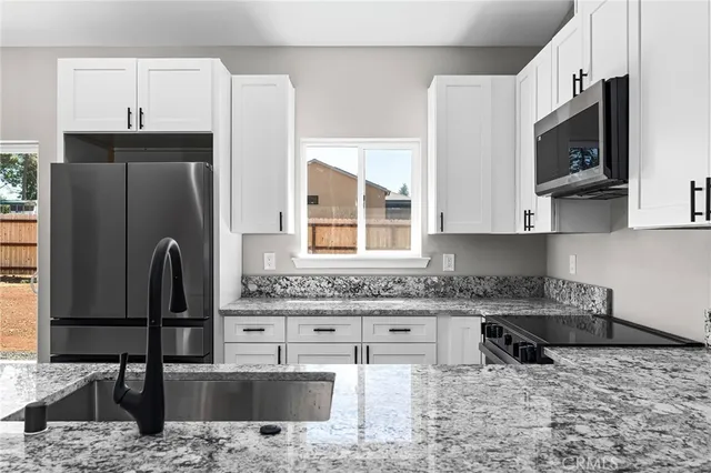 a kitchen with stainless steel appliances granite countertop a sink stove and microwave