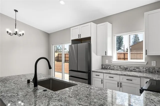 a kitchen with granite countertop a refrigerator and a granite counter tops