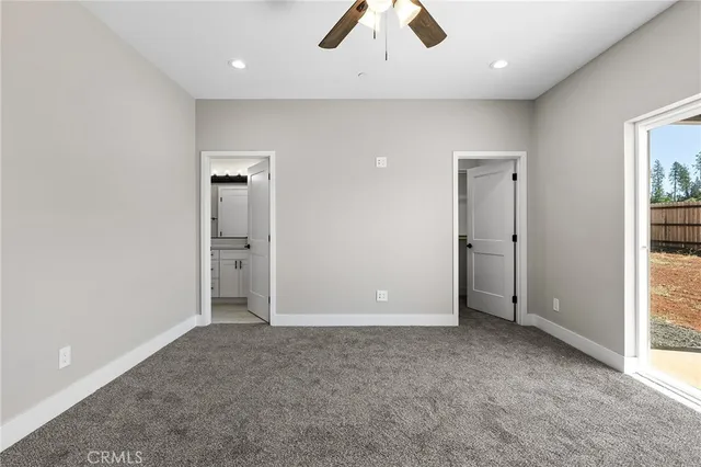 an empty room with closet and a chandelier fan