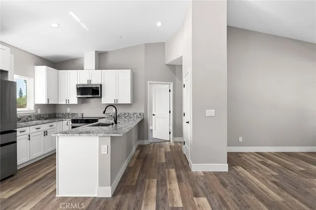 a kitchen with granite countertop a sink stove and refrigerator