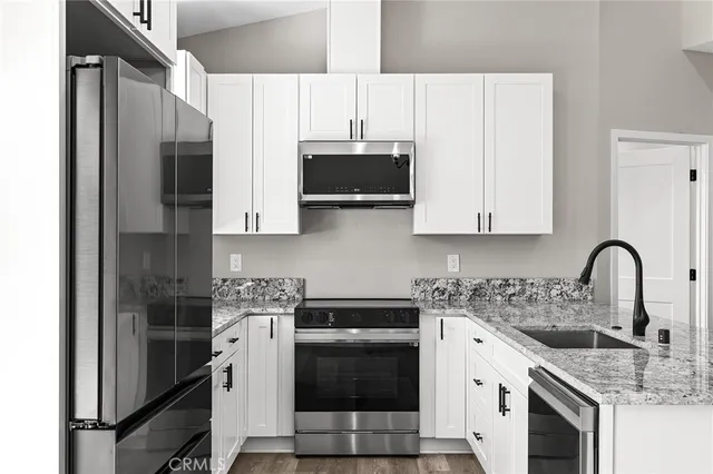 a kitchen with stainless steel appliances a stove a sink a microwave and cabinets