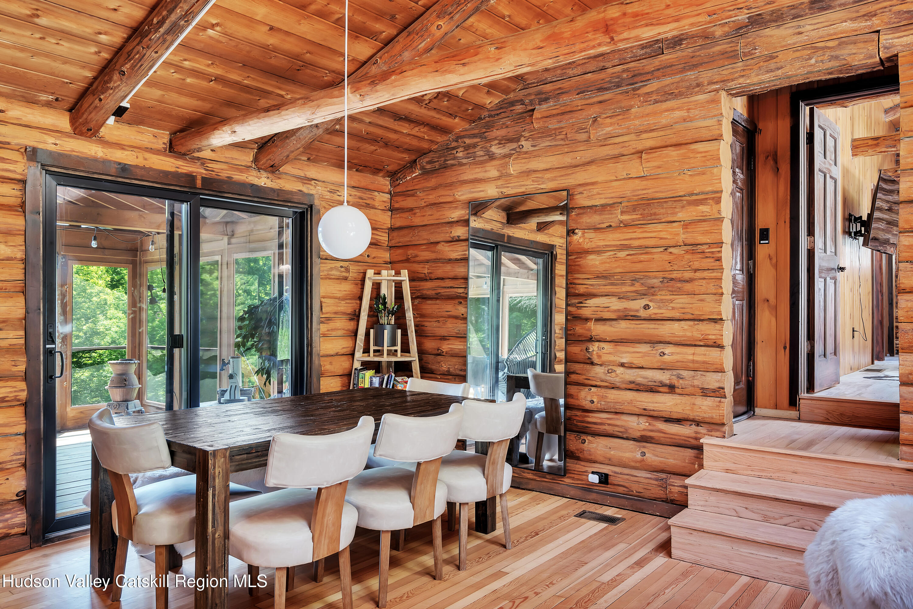 38 Woodchuck Road Roxbury, NY 12421 - Photo 14 of 33 a view of a patio with a table and chairs and floor to ceiling window with wooden floor