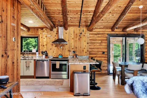 a open kitchen with stainless steel appliances granite countertop a stove roof table and chairs