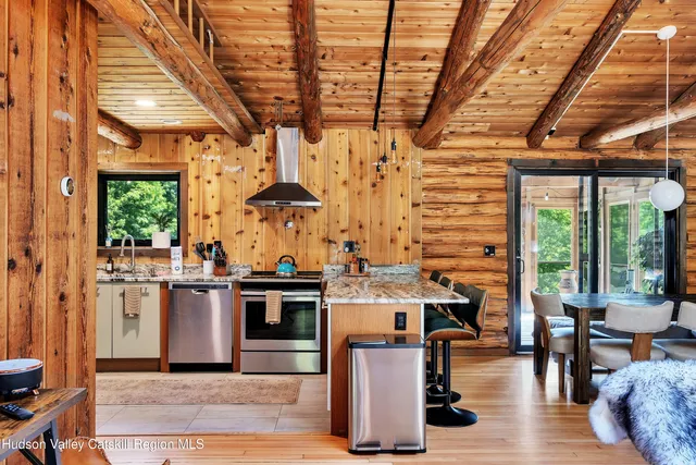 a open kitchen with stainless steel appliances granite countertop a stove roof table and chairs