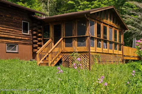 a view of a house with large windows and flower plants