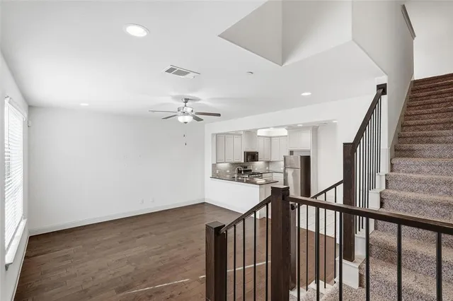 a view of a hallway with wooden floor and staircase