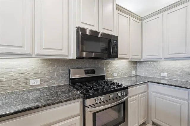 a kitchen with a refrigerator sink and cabinets