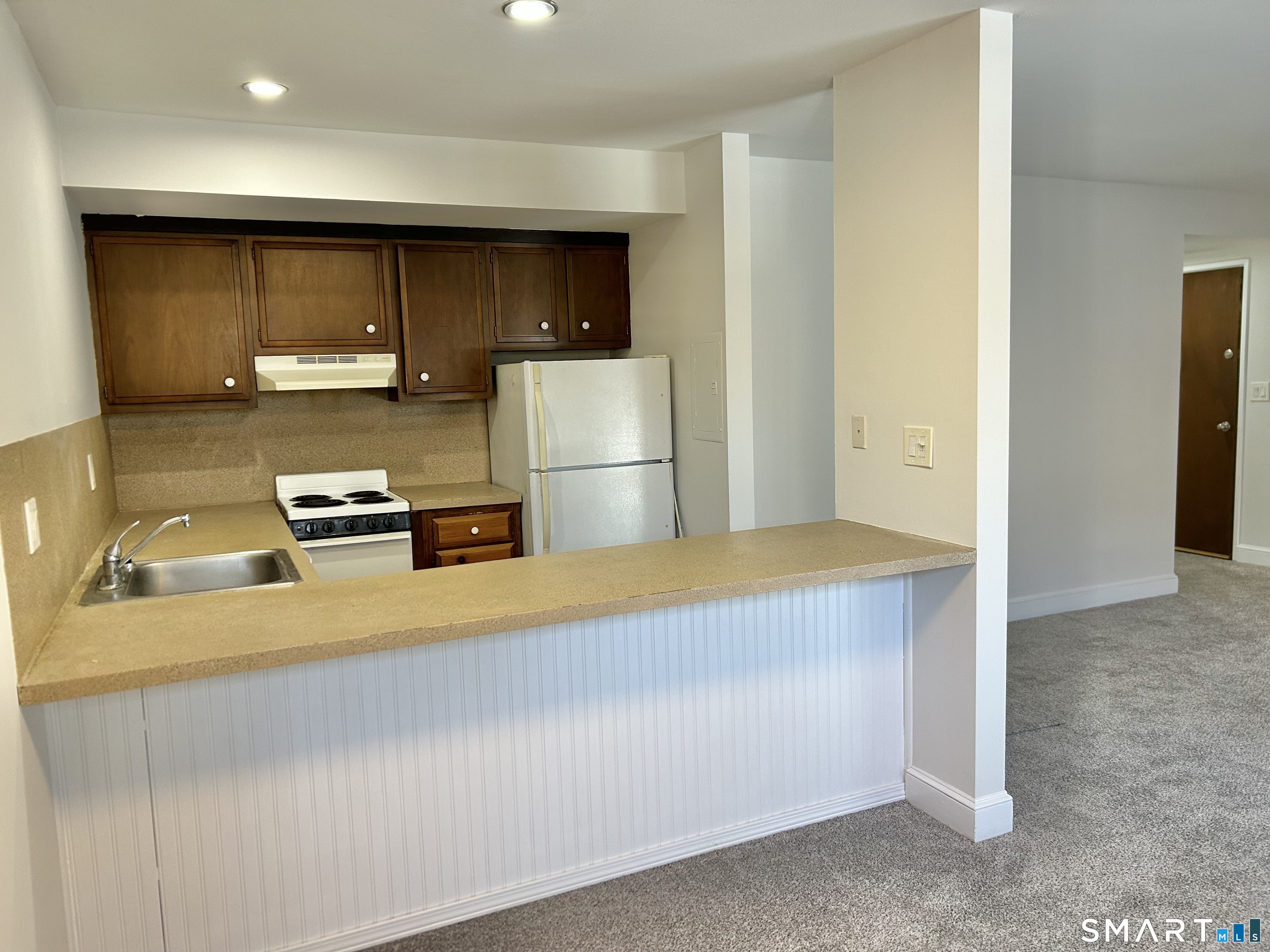 229 Bacon Pond Road, Unit 312 Woodbury, CT 06798 - Photo 5 of 17 a kitchen with a refrigerator and a sink
