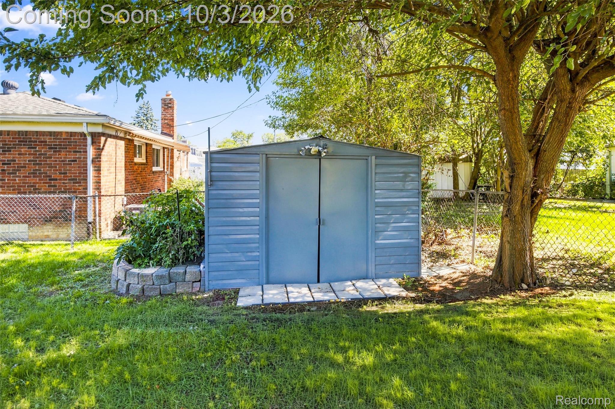 556 Henry Ruff Road Garden City, MI 48135 - Photo 31 of 49 Freestanding storage shed with double doors, stone paver pathway, and surrounding grassy area