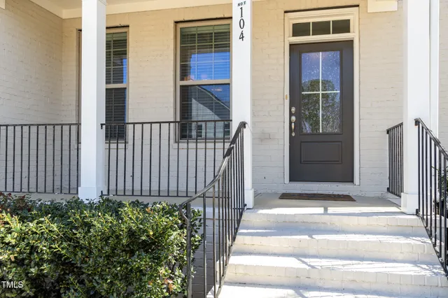 a view of a house with a small yard and potted plants