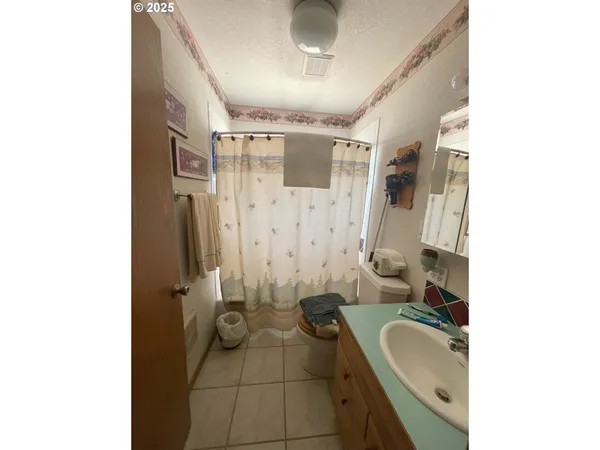 a bathroom with a granite countertop sink a toilet and shower