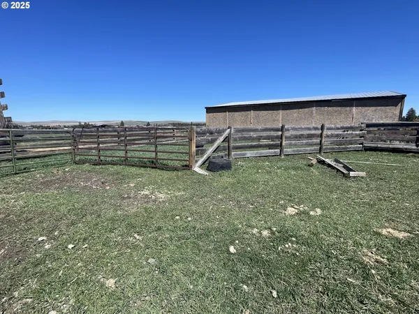 a view of a green field with some trees in the background