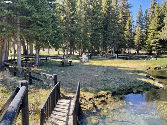 a view of a swimming pool with a patio and wooden fence