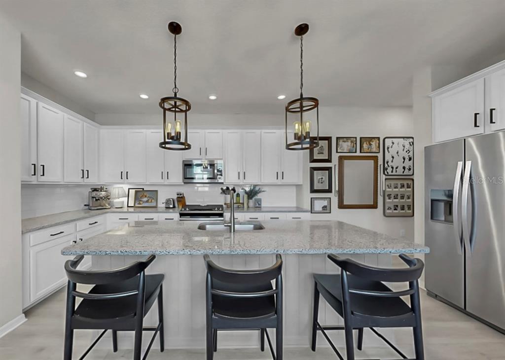 7206 Paradiso Drive Apollo Beach, FL 33572 - Photo 13 of 44 a kitchen with refrigerator and chairs