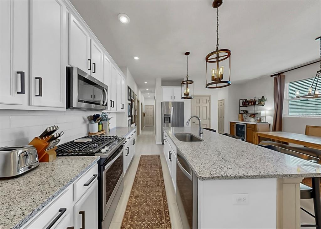 7206 Paradiso Drive Apollo Beach, FL 33572 - Photo 14 of 44 a kitchen with granite countertop stainless steel appliances sink stove top oven and cabinets