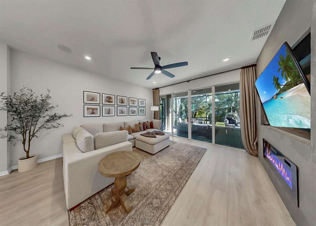 7206 Paradiso Drive Apollo Beach, FL 33572 - Photo 19 of 44 a living room with furniture a flat screen tv and a floor to ceiling window