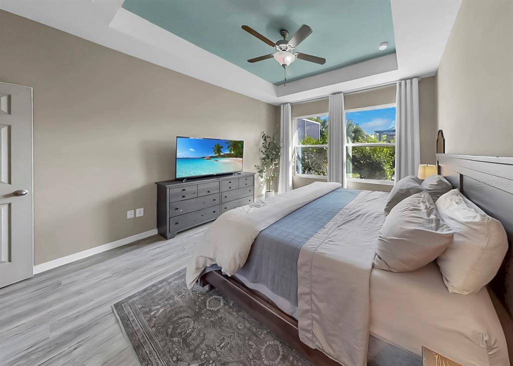 7206 Paradiso Drive Apollo Beach, FL 33572 - Photo 26 of 44 a spacious bedroom with a bed a window and a flat screen tv
