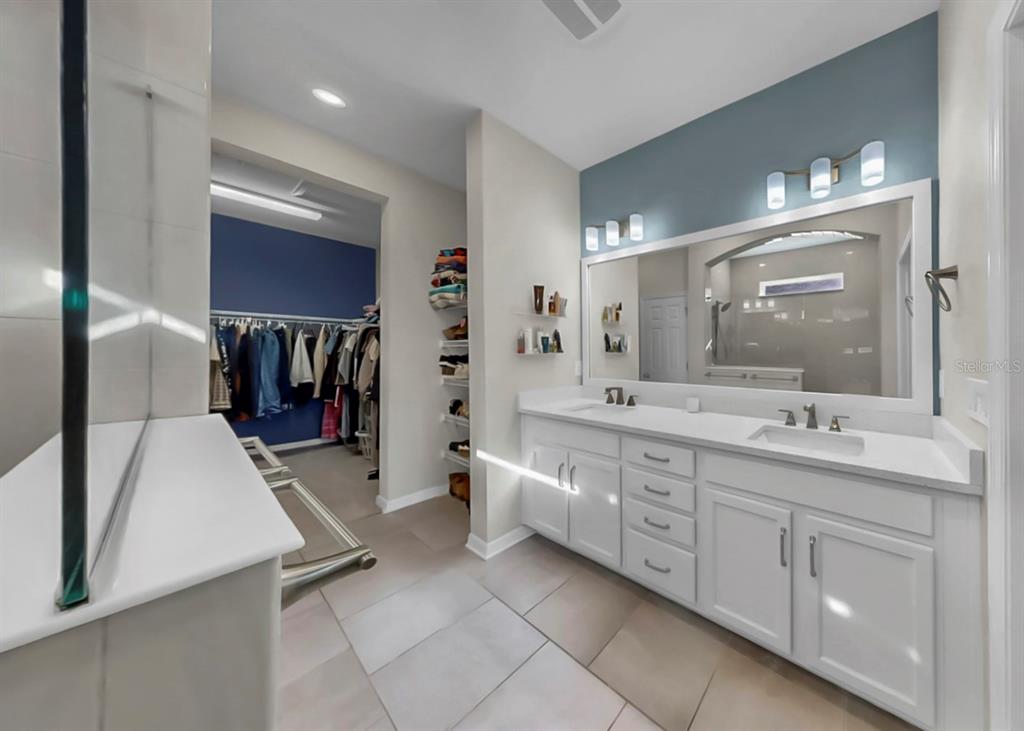 7206 Paradiso Drive Apollo Beach, FL 33572 - Photo 32 of 44 a bathroom with a double vanity sink a mirror and a bathtub