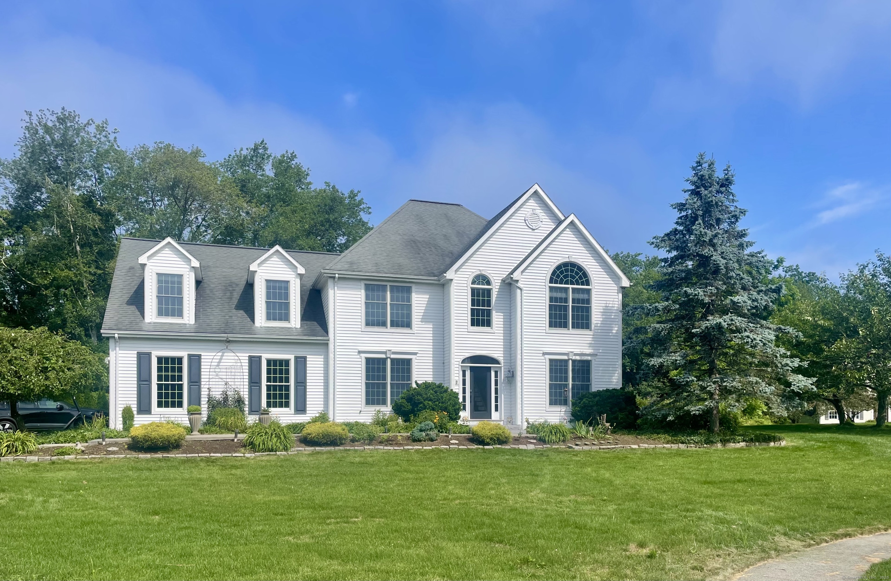 a front view of a house with a yard and trees