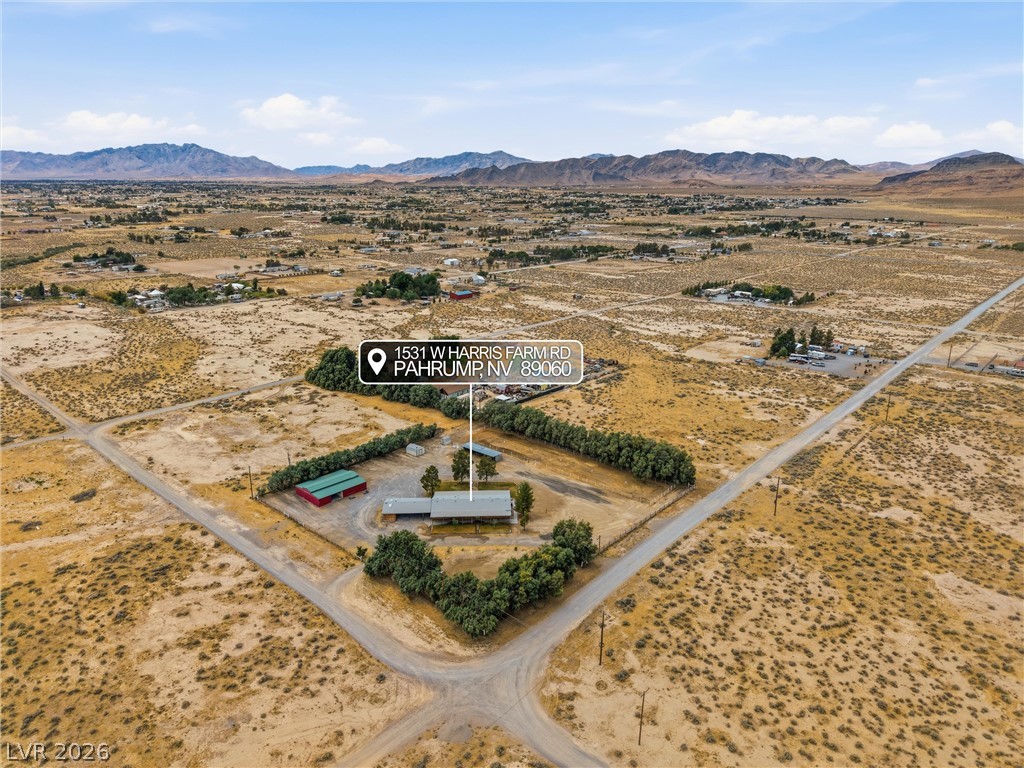 1531 West Harris Farm Road Pahrump, NV 89060 - Photo 3 of 37 An aerial perspective reveals a vast desert property with a secluded residence and distant mountain vistas.