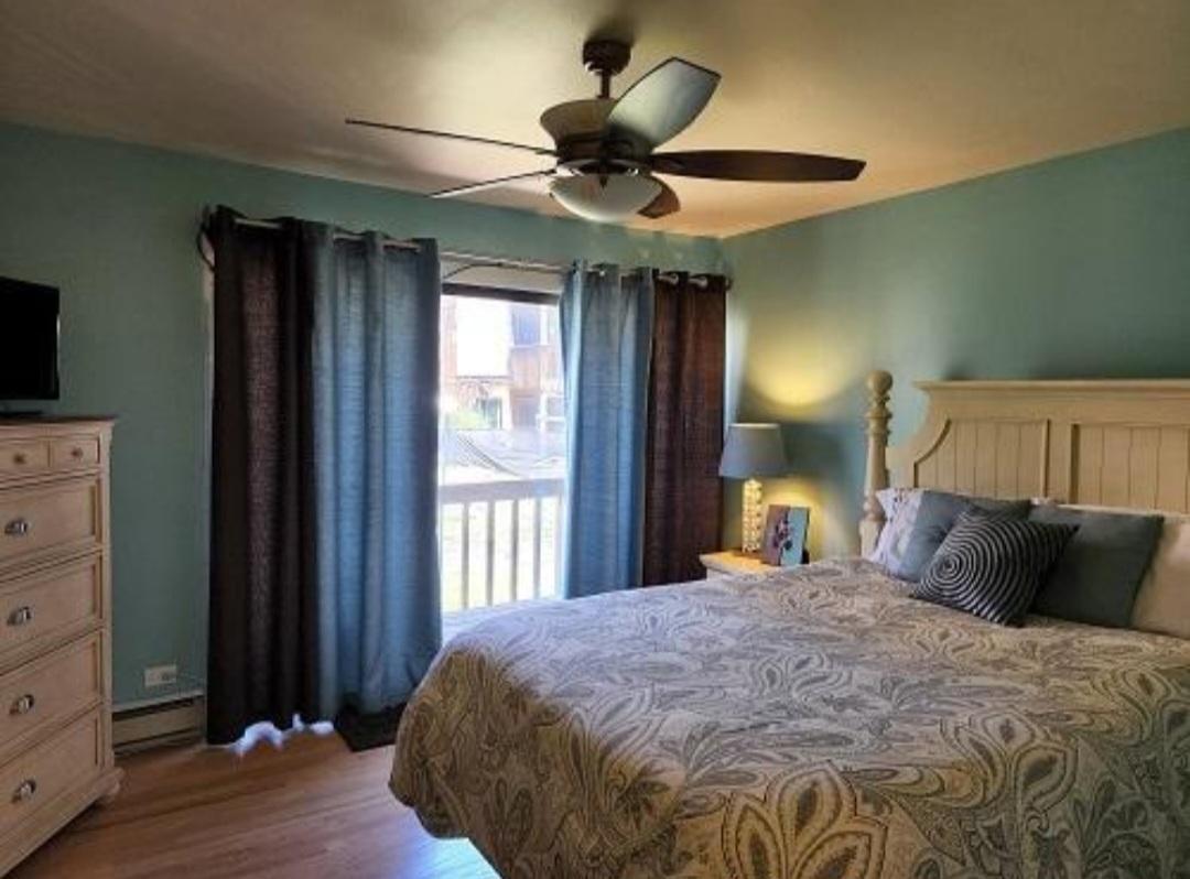 57 Vail Colony, Unit 7 Fox Lake, IL 60020 - Photo 23 of 25 a bedroom with a bed and a chandelier