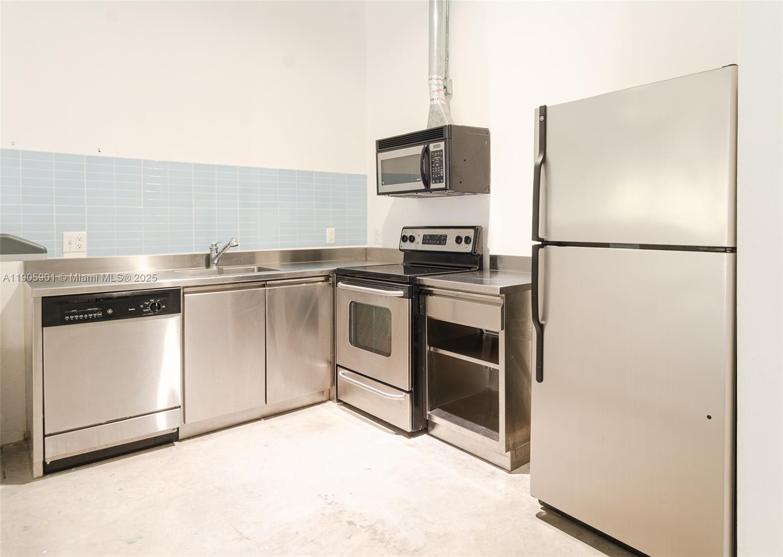 250 Northwest 23rd Street, Unit 202 Miami, FL 33127 - Photo 4 of 8 a kitchen with stainless steel appliances a refrigerator stove and microwave