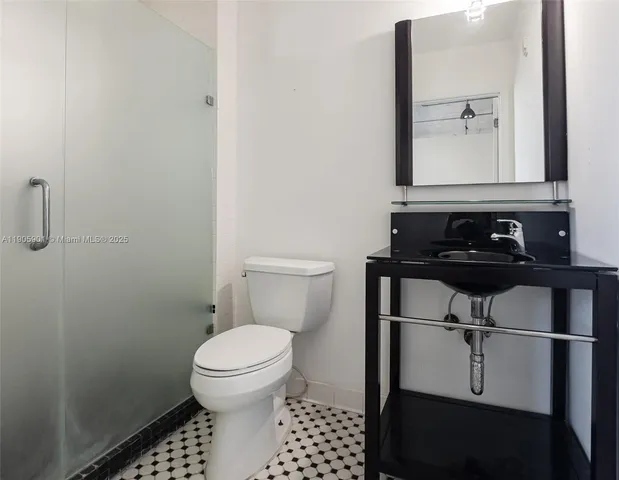 a bathroom with a toilet a sink and a mirror