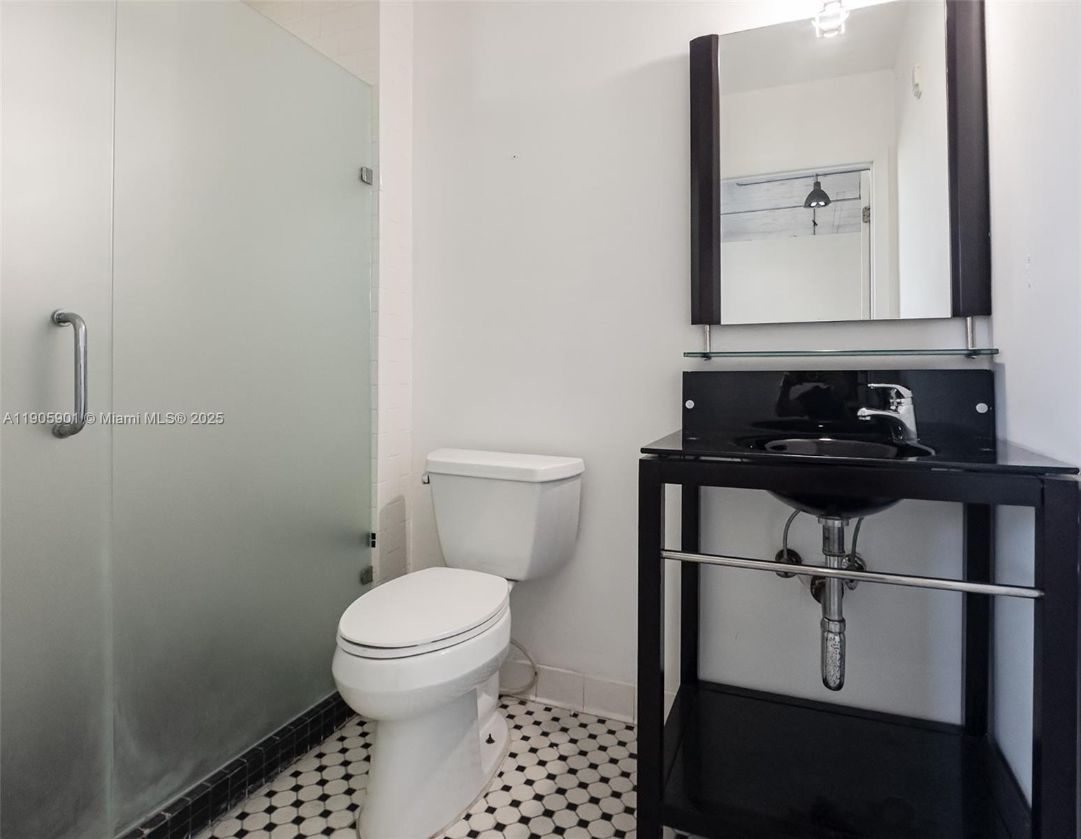 250 Northwest 23rd Street, Unit 202 Miami, FL 33127 - Photo 6 of 8 a bathroom with a toilet a sink and a mirror