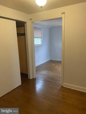 an empty room with wooden floor and closet