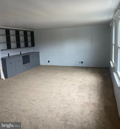 a view of an empty room with a kitchen