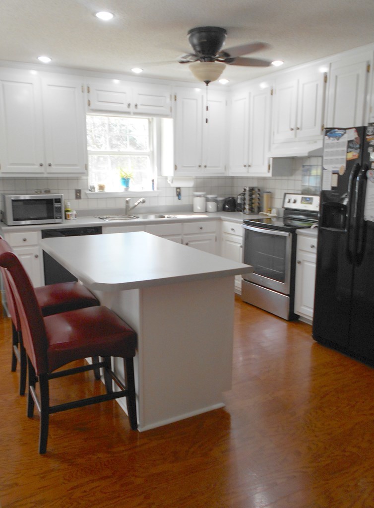 1135 Taylor Road Juliette, GA 31046 - Photo 5 of 12 a kitchen with stainless steel appliances granite countertop a table chairs sink and cabinets